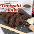Teriyaki twist snack on a slate board with soy sauce and garlic cloves in the background.